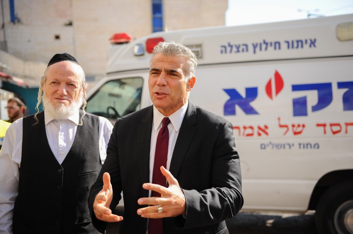 FILE - Chairman of the Yesh Atid Party, Yair Lapid seen with Yehuda Meshi Zahav (L), head of Israel's Zaka rescue unit during a visit of Lapid's at the Zaka headquarters in Jerusalem on December 23, 2015. Photo by Mendy Hechtman/Flash90