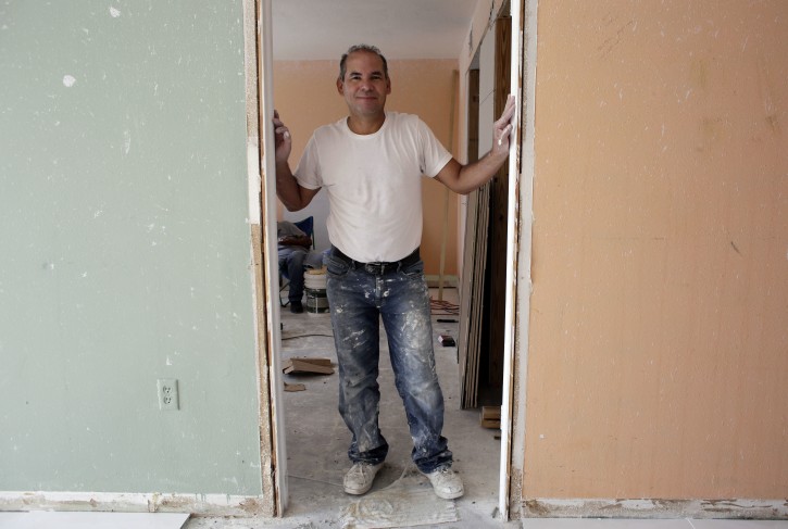 In this Monday, April 25, 2016 photo, Edgar Ospina, 50, poses for a photo where he is remodeling an apartment in Miami Beach, Fla. Ospina, who has spent almost half of his life in America after emigrating from his native Colombia, recently applied for naturalization. He was motivated to apply due to a possible Donald Trump presidency, in a year when immigration has taken center stage in the presidential campaign. (AP Photo/Lynne Sladky)