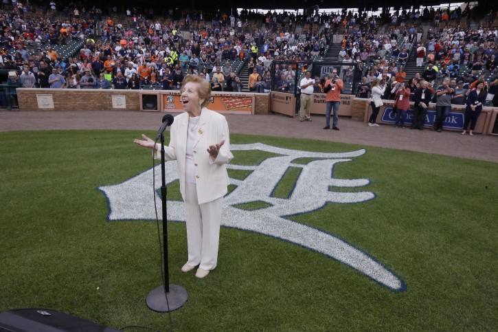 Hermina Hirsch, 89, a Holocaust survivor, sings the national anthem before the baseball game between the Detroit Tigers and the Tampa Bay Rays, Saturday, May 21, 2016, in Detroit. Hirsch's bucket list included singing the anthem before a Tigers game. (AP Photo/Carlos Osorio)