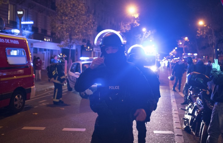 FILE- In this Friday, Nov. 13, 2015 file photo, elite police officers arrive outside the Bataclan theater after several dozen people were killed in attacks around Paris. A French Islamic State cell dismantled in the final stages of planning an attack has yielded a new secret in the first week of May 2016, with the release of undercover footage showing how a group of disaffected petty criminals transformed into a terror network. (AP Photo/Kamil Zihnioglu, File)