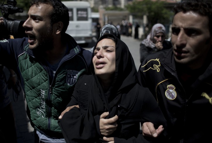 The mother of three children who were killed in a fire caused by a candle mourns during their funeral in the Shati refugee camp in Gaza City, Saturday, May. 7, 2016. Three Palestinian children have been killed in a Gaza house fire started by a candle, sparking internal finger-pointing over the coastal territory's lingering power crisis. (AP Photo/ Khalil Hamra)