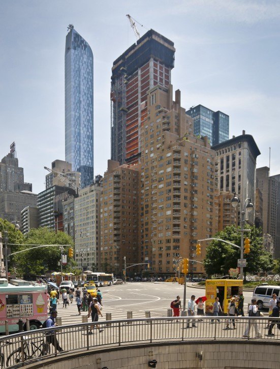 A luxury 90-floor apartment skyscraper called "One57," left, rises above all other buildings overlooking Central Park, while a crane sits atop ongoing construction for a new condominium skyscraper at 220 Central Park South, Thursday May 26, 2016, in New York. A penthouse in One57 went for $100.5 million in 2014, but an apartment in the new condominium is expected to sell for $250 million. (AP Photo/Bebeto Matthews)
