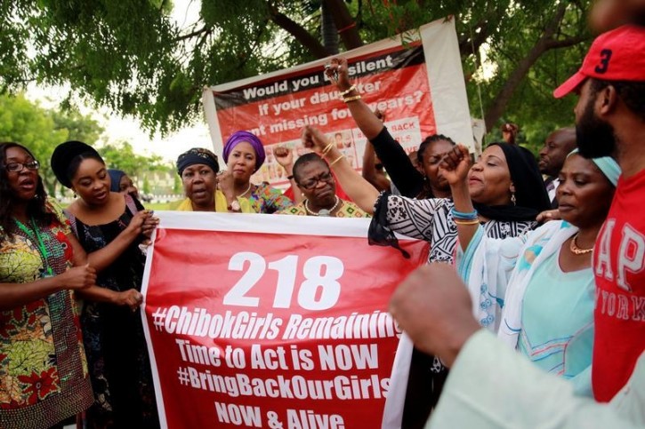 Members of the #BringBackOurGirls (#BBOG) campaign stand behind a banner with Number 218 during a sit-out in Abuja, Nigeria May 18, 2016, after receiving news that a Nigerian teenager kidnapped by Boko Haram from her school in Chibok more than two years ago has been rescued. REUTERS/Afolabi Sotunde