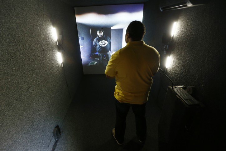  In a photo taken Friday, May 27, 2016, Divad Sanders, right, stands inside a container in Newark, N.J., as he converses with Lewis Lee, standing in a container in Milwaukee, as part of an art installation at Military Park in downtown Newark, N.J. The portal allows people inside a container to communicate to people in containers in other cities across the world. (AP Photo/Julio Cortez)