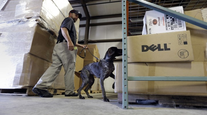 In this Thursday, June 9, 2016, photo, Transportation Security Administration dog trainer Ford Rinewalt works with Sylvia, a bomb-sniffing dog, in a makeshift warehouse during a drill at Lackland Air Force Base in Texas. Short-staffed and often criticized, the TSA aims to improve training for airport screeners. (AP Photo/Eric Gay)