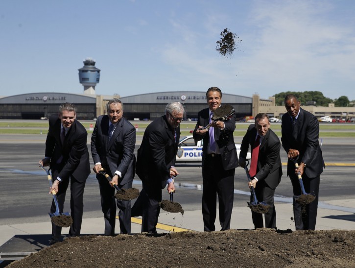 Joined by other officials, New York Gov. Andrew Cuomo, third from right, throws dirt in the air during a ceremonial ground breaking on the tarmac at LaGuardia Airport in New York, Tuesday, June 14, 2016. Cuomo held a news conference to talk about the planned infrastructure improvements at the airport. (AP Photo/Seth Wenig)