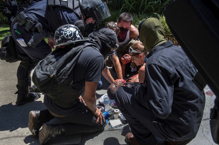A victim is attended after he was stabbed during a rally at the State Capitol in Sacramento, Calif., on Sunday, June 26, 2016. Sacramento Fire Department spokesman Chris Harvey says a rally by KKK and other right-wing extremists groups turned violent Sunday when they were met by counterprotesters. (Rene C. Byer/The Sacramento Bee via AP)