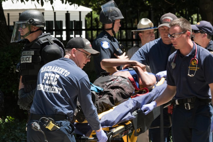 Paramedics rush a stabbing victim away on a gurney Sunday, June 26, 2016, after members of right-wing extremists groups holding a rally outside the California state Capitol building in Sacramento clashed with counter-protesters, authorities said. Sacramento Police spokesman Matt McPhail said the Traditionalist Workers Party had scheduled and received a permit to protest at noon Sunday in front of the Capitol. McPhail said a group showed up to demonstrate against them. (AP Photo/Steven Styles)