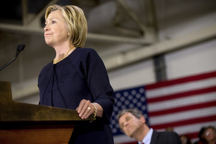 Democratic presidential candidate Hillary Clinton, left, accompanied by Sen. Sherrod Brown, D-Ohio, right, speaks at a rally at a warehouse for the company "Team Wendy" which produces helmets for military, law enforcement, and rescue teams, in Cleveland, Monday, June 13, 2016. (AP Photo/Andrew Harnik)