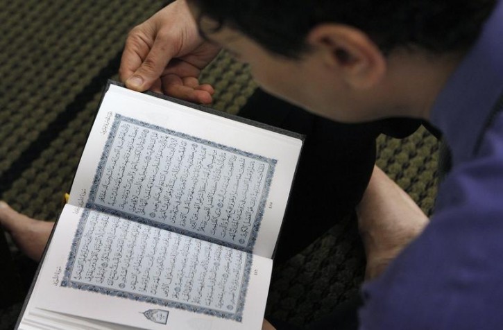 FILE - A member of Chicago's Muslim community reads from the Quran after afternoon prayer at the Downtown Islamic Center in Chicago March 10, 2011. REUTERS/Frank Polich 