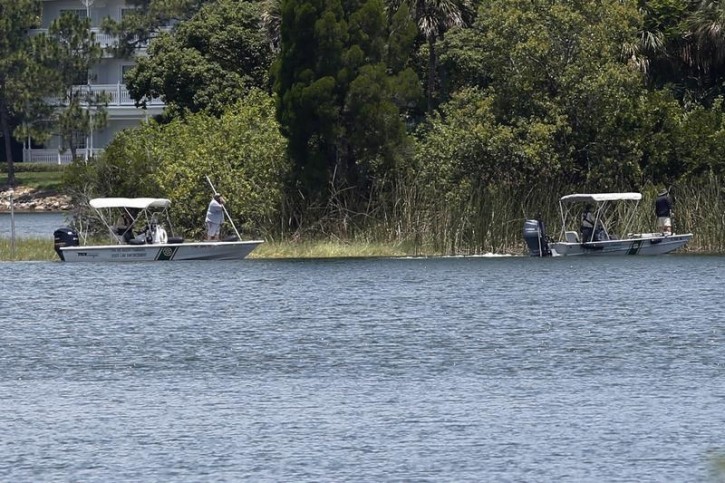 FILE - Wildlife officials search the Seven Seas lagoon at Walt Disney World resort after an alligator dragged a two-year-old boy into the water in Orlando, Florida, U.S. June 15, 2016.   REUTERS/Adrees Latif 