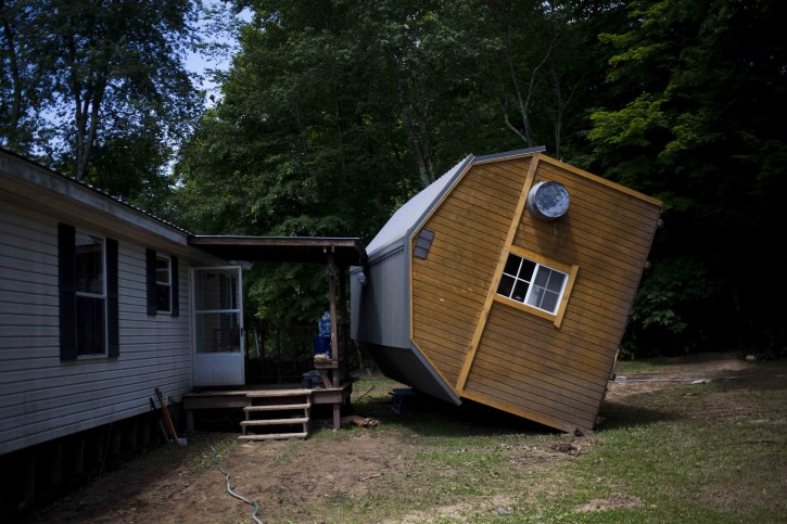 An uprighted storage shed leans against a home in Rupert, W.Va., Sunday, June 26, 2016. (Christian Tyler Randolph/Charleston Gazette-Mail via AP)