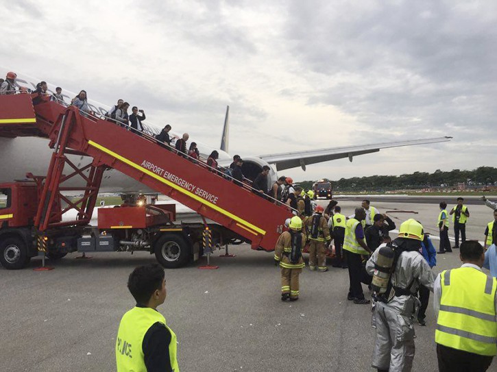 This image provided by Lee Bee Yee shows shows passengers disembarking   a Singapore Airlines flight after an engine fire on Monday, June 27, 2016. A Singapore Airlines statement said the Boeing 777-300ER was on its way to Milan when it turned back 
