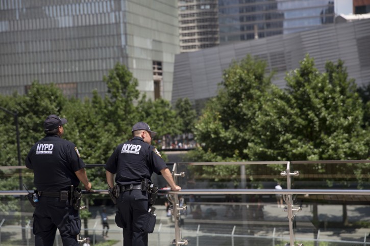 Police officers with the counterterrorism unit stand guard in Liberty Park overlooking the the memorial Wednesday, June 29, 2016, in New York. The one-acre, elevated Liberty Park opened to the public Wednesday. Built on top of a security center, it overlooks the memorial to those who died in the Sept. 11 attacks. (AP Photo/Mary Altaffer)