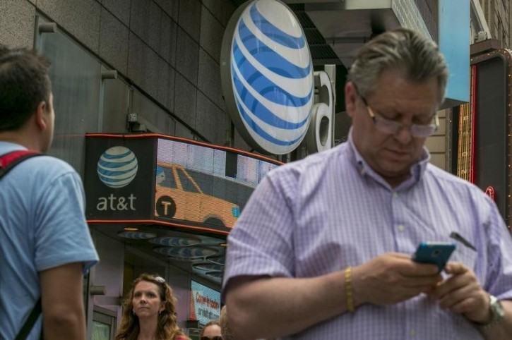 FILE - A man uses his phone outside the AT&T store in New York's Times Square, June 17, 2015. REUTERS/Brendan McDermid