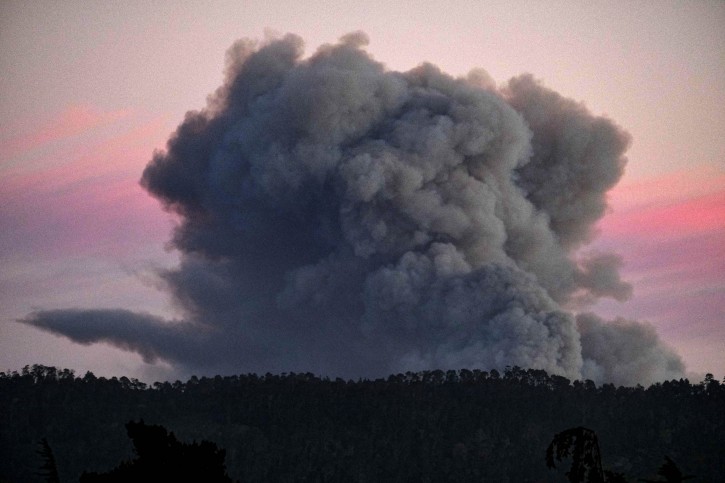 A large plume of smoke from a wildfire rises near Highway 1, burning five miles south of Carmel, Calif., on Friday, July 22, 2016. (AP Photo/Richard Vogel)