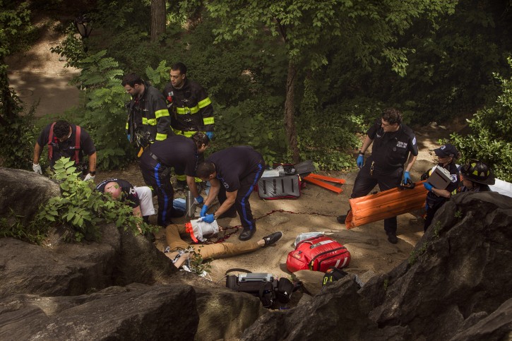 A man, center bottom, bleeds from his injured leg as he gets helped from paramedics, firemen, and police in Central Park in New York, Sunday, July 3, 2016. AP