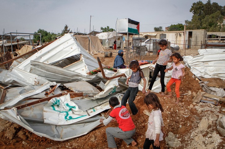 FILE - A Palestinian family sits in the remains of their demolished home in the West Bank village of Um Alkahiar, South of Hebron on April 6, 2016.  Flash90