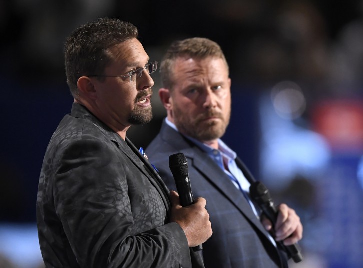 John Tiegen, a U.S. Marine Corp veteran, left, and Mark Geist, a U.S. Marine Corps veteran who fought in Benghazi, speak during the opening day of the Republican National Convention in Cleveland, Monday, July 18, 2016. . (AP Photo/Mark J. Terrill)