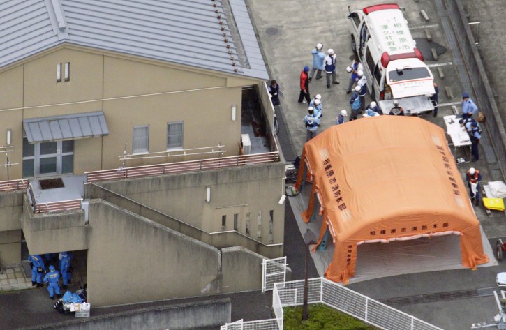 Ambulance crew and police officers are seen outside a facility for the handicapped where a number of people were killed and dozens injured in a knife attack Tuesday, July 26, 2016,  in Sagamihara, outside Tokyo. (Kyodo News via AP)