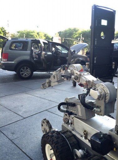 In this photo provided by the NYPD, a police robot is shown next to a suspect's vehicle following a standoff, Thursday, July 21, 2016 at Columbus Circle in New York. (NYPD via AP )