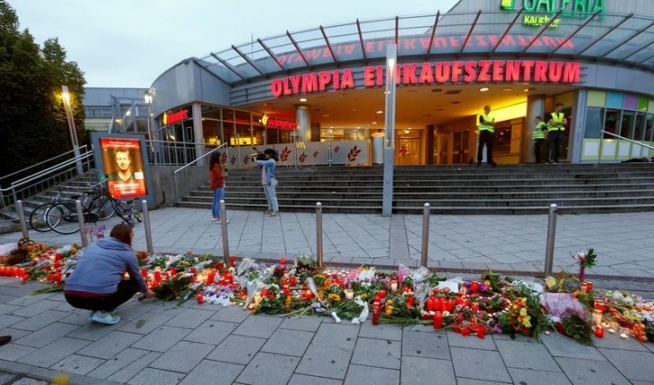 A woman lays flowers in front of the Olympia shopping mall, where yesterday's shooting rampage started, in Munich, Germany July 23, 2016. REUTERS/Arnd Wiegmann