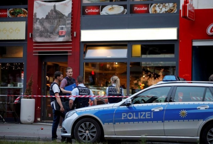 Police stand outside where a 21-year-old Syrian refugee killed a woman with a machete and injured two other people in the city of Reutlingen, Germany July 24, 2016. REUTERS/Vincent Kessler 