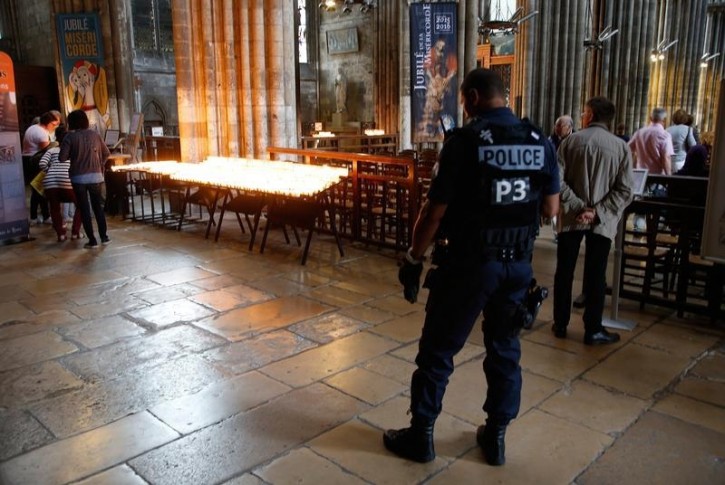 A French policeman stands guard as people attend a mass to pay tribute to French priest Father Jacques Hamel at the Cathedral in Rouen in Normandy, France, July 27, 2016.  Reuters