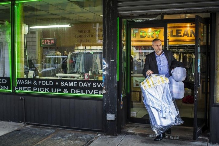 FILE - A man walks with dry cleaning out of a store in New York April 13, 2015. REUTERS/Lucas Jackson