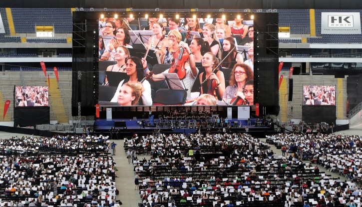  Musicians watch themselves on a giant video screen in the Commerzbank Arena stadium as the members of a mass orchestra are rehearsing for a World Record attempt on the pitch of the stadium in Frankfurt, Germany, 09 July 2016. EPA