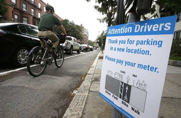 In this Tuesday, Aug. 16, 2016 photo a cyclist rides in a bike lane between parked cars, left, and the sidewalk, right, in Boston. Boston, Chicago, New York and other U.S. cities are reconfiguring bike lanes to make them safer in light of a spate of fatal accidents involving cyclists and cars. (AP Photo/Steven Senne)
