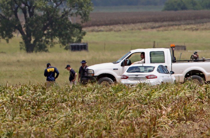 Investigators work the scene of Saturday's hot air balloon crash near Maxwell, Texas, Sunday, July 31, 2016. A hot air balloon made contact with high-tension power lines before crashing into a pasture in Central Texas, killing all on board, according to federal authorities who are investigating the worst such disaster in U.S. history. (Edward A. Ornelas/The San Antonio Express-News via AP)