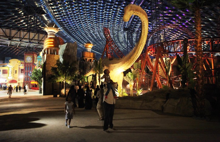 A man puts a small boy on his shoulders to look at an animatronic dinosaur at the IMG Worlds of Adventure amusement park in Dubai, United Arab Emirates, on Wednesday, Aug. 31, 2016. The IMG Worlds of Adventure indoor theme park opened Wednesday in Dubai, hoping to draw thrill seekers to its air-conditioned confines. (AP Photo/Jon Gambrell)