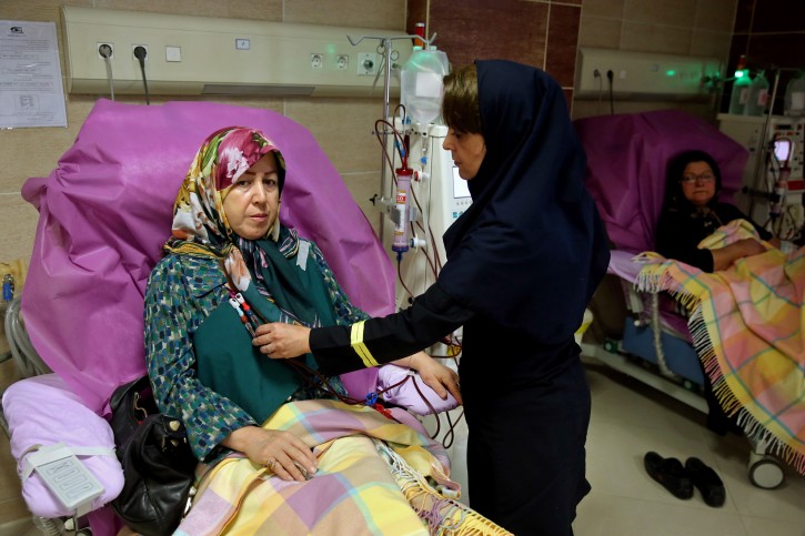 In this picture taken on Saturday, Aug. 6, 2016, Iranian Zahra Hajikarimi uses a dialysis machine as a nurse attends her in a clinic in downtown Tehran, Iran. (AP Photo/Ebrahim Noroozi