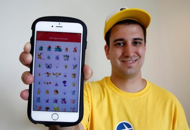 Nick Johnson, the first person to beat "Pokemon Go" and capture all 145 Pokemon, poses with his mobile phone showing Pokemon characters he captured in Tokyo, Japan, August 8, 2016. REUTERS/Kim Kyung-Hoon
