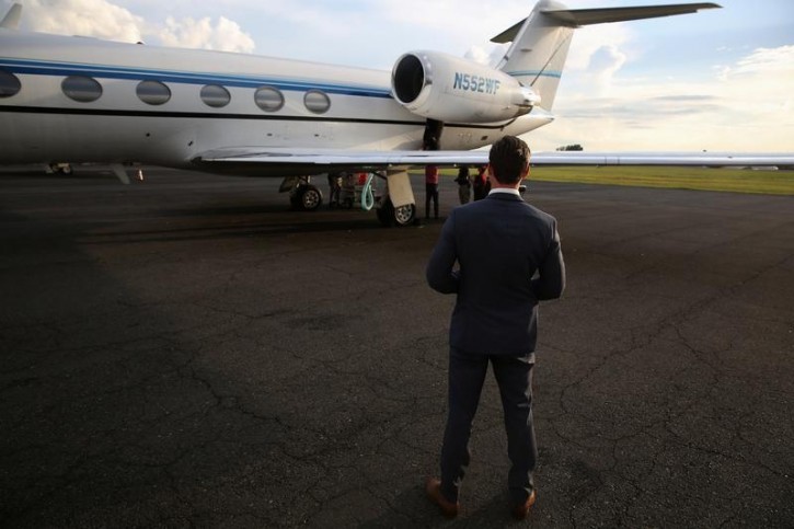 A Secret Service agent watches a charter plane used by media covering Republican presidential candidate Donald Trump during the election in Charlotte, North Carolina, U.S., August 17, 2016. REUTERS/Carlo Allegri 