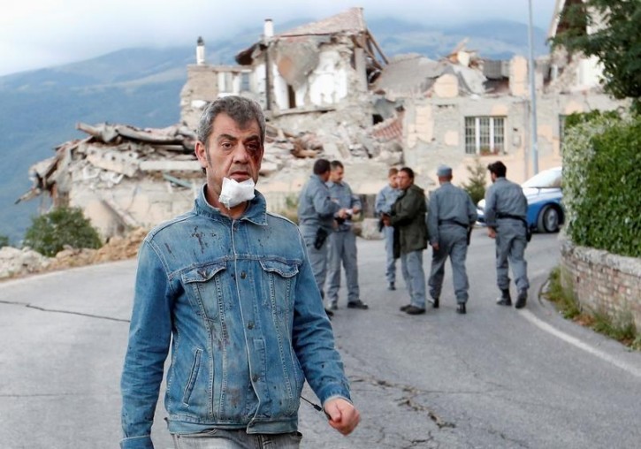 wounded man walks along the road following an earthquake in Amatrice, central Italy, August 24, 2016. Picture taken August 24, 2016. REUTERS/Remo Casilli 