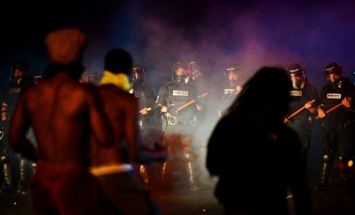 Officers stand in formation in front of protesters in Charlotte, N.C. on Tuesday, Sept. 20, 2016. Authorities used tear gas to disperse protesters in an overnight demonstration that broke out Tuesday after Keith Lamont Scott was fatally shot by an officer at an apartment complex. (Jeff Siner/The Charlotte Observer via AP)