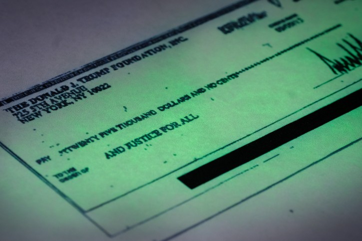 This photo made in the Associated Press Washington bureau on Thursday, Sept. 15, 2016 shows a copy of a check provided by the New York state attorney general that shows a payment of $25,000 from the Donald J. Trump Foundation to And Justice For All signed by Donald J. Trump. The $25,000 check was sent from his personal foundation to a political committee supporting Florida Attorney General Pam Bondi. Charities are barred from engaging in political activities. Trumpâs campaign contends that the 2013 check from the Trump Foundation was mistakenly issued following a series of clerical errors and that Trump intended to use personal funds. (AP Photo/J. David Ake)