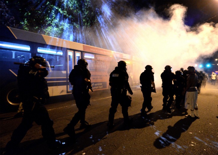 Charlotte-Mecklenburg police officers walk through a haze of tear gas on Old Concord Rd. in Charlotte, NC on Tuesday night. A protest began on Old Concord Road at Bonnie Lane, where a Charlotte-Mecklenburg police officer fatally shot a man in the parking lot of The Village at College Downs apartment complex Tuesday afternoon.The man who died was identified late Tuesday as Keith Scott, 43 and the officer who fired the fatal shot was CMPD Officer Brentley Vinson.