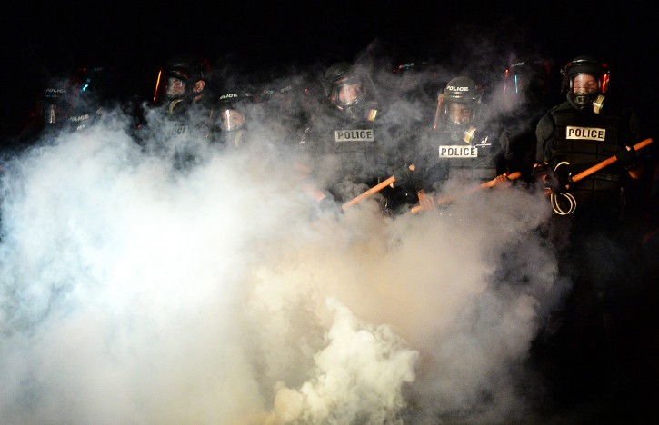 CMPD officers stand in a haze of tear gas on Old Concord Road in Charlotte, NC on Tuesday night. A protest began on Old Concord Road at Bonnie Lane, where a Charlotte-Mecklenburg police officer fatally shot a man in the parking lot of The Village at College Downs apartment complex Tuesday afternoon.The man who died was identified late Tuesday as Keith Scott, 43 and the officer who fired the fatal shot was CMPD Officer Brentley Vinson.