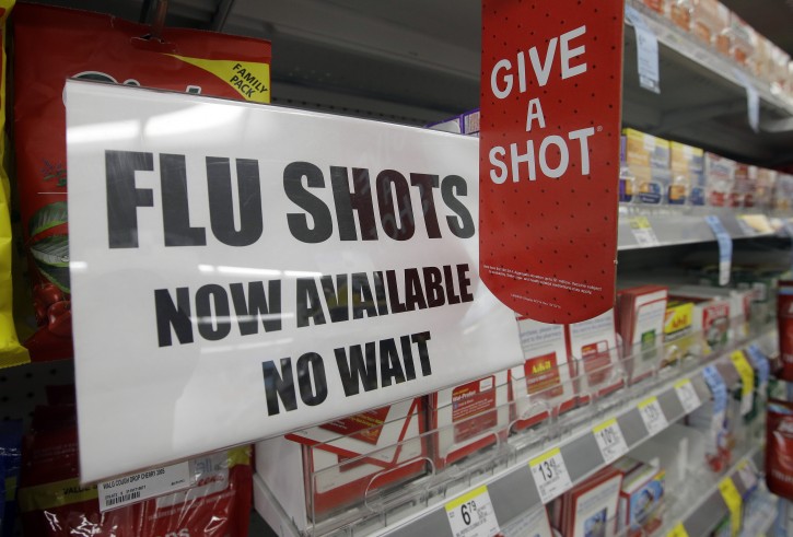 FILE - In this Sept. 16, 2014 file photo, a sign telling customers that they can get a flu shot in a Walgreen store is seen in Indianapolis. Kids may get more of a sting from flu vaccination this fall: Doctors are gearing up to give shots only, because U.S. health officials say the easy-to-use nasal spray version of the vaccine isn't working as well as a jab. (AP Photo/Darron Cummings, File)