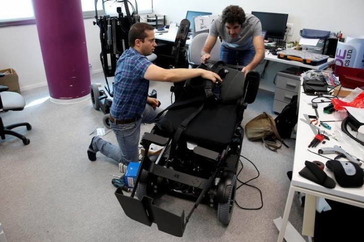 Employees work on a wheelchair developed by Israeli company UPnRIDE Robotics, that enables paralysed people with limited function in their arms to stand upright, during a demonstration at their offices in Yoqneam, Israel September 6, 2016. REUTERS/Baz Ratner 