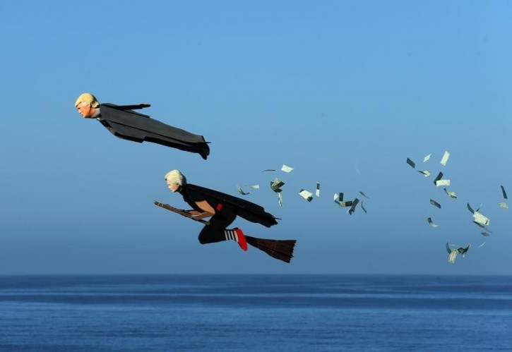 Model plane builder Otto Dieffenbach III makes his remote control plane resembling U.S. Presidential candidate Donald Trump release fake money as it flies over the beach next to a similar plane resembling Hillary Clinton in Carlsbad, California, U.S. September 15, 2016. REUTERS/Mike Blake 