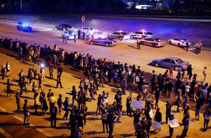 Protesters head onto the highway during another night of protests over the police shooting of Keith Scott in Charlotte, North Carolina, U.S. September 22, 2016.  REUTERS/Mike Blake 