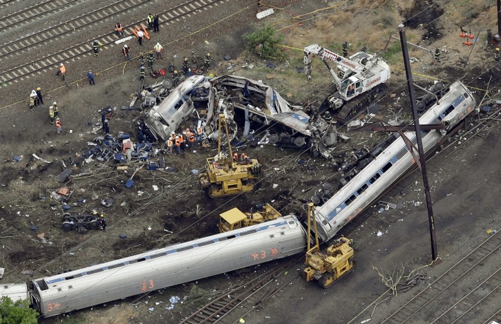 FILE- In this Wednesday, May 13, 2015, file photo, emergency personnel work at the scene of a derailment in Philadelphia of an Amtrak train headed to New York. Amtrak will pay about $265 million to settle claims related to a deadly derailment in Philadelphia that killed eight people and injured more than 200 others. Lawyers who negotiated the settlement said people will have their awards in hand by June instead of going through years of legal wrangling. (AP Photo/Patrick Semansky, File)