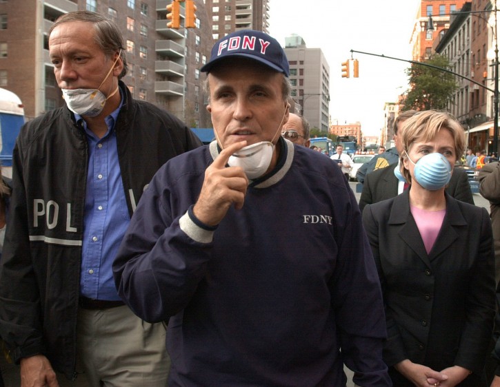 FILE - In this Wednesday, Sept. 12, 2001 file photo, New York City Mayor Rudolph Giuliani, center, leads New York Gov. George Pataki, left, and Sen. Hillary Rodham Clinton, D-N.Y., on a tour of the site of the World Trade Center disaster.  He was the living symbol of the Sept. 11, 2001, terror attacks, a hero to a traumatized nation seeking leadership in a time of crisis. Walking miles through the streets of Manhattan, Giuliani urged New York and the world to be calm, said the city would survive. With empathy and restraint, he said the number of 9/11 dead would be "more than any of us can bear." (AP Photo/Robert F. Bukaty, File)