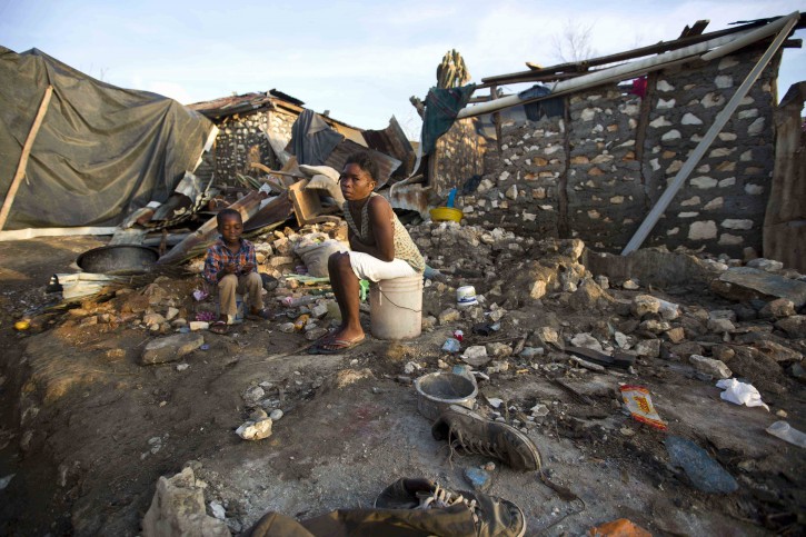 A woman sit on the ground of her destroyed home by Hurricane Matthew in Jeremie, Haiti on Monday, Oct. 10, 2016. Jeremie appears to be the epicenter of the country's growing humanitarian crisis in the wake of the storm. (AP Photo/Dieu Nalio Chery)
