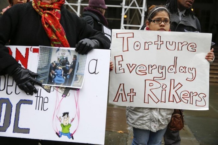FILE - Aida Garcia,19, stands with a sign during a rally regarding the NYC Board of Correction hearing on the Department of Correction (DOC) proposal to create enhanced supervision housing units (ESHU) in the city jails, on the steps of City Hall in New York December 10, 2014. REUTERS/Shannon Stapleton 