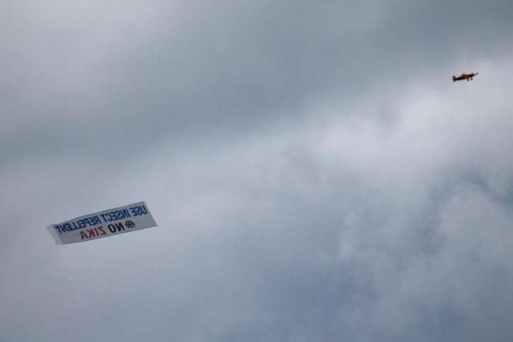 FILE - An airplane carrying a banner asking people to use insect repellent to avoid the Zika virus, flies over Miami, Florida, U.S., September 13, 2016. REUTERS/Carlo Allegri -